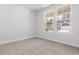 Minimalist bedroom features plush carpeting, neutral walls, and double windows for ample natural light at 1099 Nw Forest Bend Dr., Calabash, NC 28467
