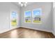 Bright dining area featuring wood floors, a modern chandelier, and a door leading to the outdoors at 1099 Nw Forest Bend Dr., Calabash, NC 28467