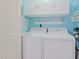 Bright laundry room with white washer and dryer, overhead cabinets, and beachy decor at 1107 Ganton Way, Myrtle Beach, SC 29588