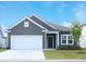Charming single-Gathering home with gray siding, a two-car garage, and a well-manicured lawn at 1336 Winding Creek Way, Myrtle Beach, SC 29588