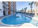 Relaxing kidney-shaped pool with palm trees and building in background at 1501 S Ocean Blvd. # 623, Myrtle Beach, SC 29577