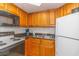 Cozy kitchen features light wood cabinets, stainless steel sink, and white appliances at 1501 S Ocean Blvd. S # 1450, Myrtle Beach, SC 29577