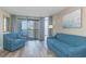 Bright living room features comfortable blue seating, balcony access and beautiful city views at 1501 S Ocean Blvd. S # 1450, Myrtle Beach, SC 29577