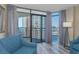 Bright living room features comfortable blue seating, balcony access and beautiful city views at 1501 S Ocean Blvd. S # 1450, Myrtle Beach, SC 29577