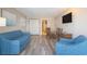 Cozy living room with modern wood flooring, a blue sofa, a dining table, and a flat screen TV at 1501 S Ocean Blvd. S # 1450, Myrtle Beach, SC 29577