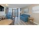 Bright living room features comfortable blue seating, balcony access and beautiful city views at 1501 S Ocean Blvd. S # 1450, Myrtle Beach, SC 29577