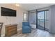 Bright living room features a comfortable blue chair, balcony access and beautiful city views at 1501 S Ocean Blvd. S # 1450, Myrtle Beach, SC 29577