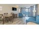 This living room features a dining table, seating, a flat screen TV, and sliding glass doors with ocean views at 1501 S Ocean Blvd. S # 1450, Myrtle Beach, SC 29577