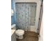 Bathroom featuring a toilet, shower with a seashell curtain, and modern wood-look flooring at 2701 S. Ocean B S Ocean Blvd. # 508, North Myrtle Beach, SC 29582