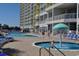 Exterior capture of condo resort pool area and splashpad with blue lounge chairs on brick patio at 2701 S. Ocean B S Ocean Blvd. # 508, North Myrtle Beach, SC 29582