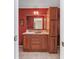 Wood vanity with sink and storage in a red-walled bathroom at 3790 Woodridge Circle, Little River, SC 29566