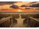 Wooden staircase leading to sandy beach at sunset at 3790 Woodridge Circle, Little River, SC 29566