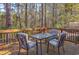 Deck with a glass-top table and chairs, wooded background at 3790 Woodridge Circle, Little River, SC 29566