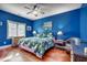 Comfortable bedroom with blue walls, tropical-themed bedding, ceiling fan, and hardwood floors at 403 20Th Ave. N, North Myrtle Beach, SC 29582