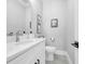 Clean, modern half bathroom with white vanity and grey tile flooring at 434 Stanley Dr., Murrells Inlet, SC 29576