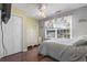 Cozy bedroom with hardwood floors, a ceiling fan, and a large window with natural light at 461 Spauldingwood Rd., Little River, SC 29566