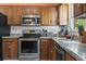 Close up of the kitchen area showcasing stainless steel appliances, wood cabinets, and granite countertops at 461 Spauldingwood Rd., Little River, SC 29566