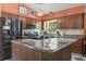 Traditional eat-in kitchen with granite countertops, stainless steel appliances, wood cabinets, and stylish light fixtures at 461 Spauldingwood Rd., Little River, SC 29566
