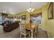 Bright dining area with a wood table and four chairs, adjacent to living room at 5090 Windsor Green Way # 104, Myrtle Beach, SC 29579