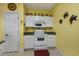 White kitchen with yellow walls and appliances at 5090 Windsor Green Way # 104, Myrtle Beach, SC 29579