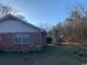 Brick house with mature trees and vegetation, offering a private backyard space at 5944 Rose Hill Rd., Georgetown, SC 29440