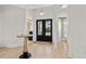 Elegant entryway with black double doors, hardwood floors, and a half bathroom at 6025 Bolsena Place, Myrtle Beach, SC 29577