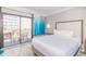Condo bedroom with balcony access, bright curtains, stylish furniture, and a large comfortable bed at 7200 N Ocean Blvd. # 314, Myrtle Beach, SC 29572