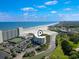 Wide aerial view of condos, Intracoastal waterway, the beach, and community tennis courts at 9400 Shore Dr. # 311, Myrtle Beach, SC 29572