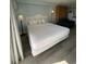 King bed with white bedding and nightstand at 1207 S Ocean Blvd. # 20205, Myrtle Beach, SC 29577