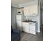 Small kitchen with white cabinets, stove, microwave, and fridge at 1207 S Ocean Blvd. # 20205, Myrtle Beach, SC 29577