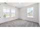 Bright bedroom with three large windows and neutral gray carpet flooring at 123 Tbd Sun Colony Blvd., Longs, SC 29568