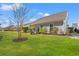 Large backyard with green lawn, grey house and walkway at 1775 Suncrest Dr., Myrtle Beach, SC 29577