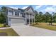 Two-story house with gray siding, white trim, and a large driveway at 1828 Hardwood Ct., Conway, SC 29526