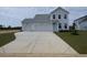 Charming two-story home featuring a two-car garage, light blue door, and a concrete driveway leading to a spacious front yard at 251 Letha Dr, Longs, SC 29568