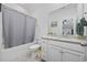 Bright bathroom with a granite countertop vanity, white cabinetry, and a shower with a gray curtain at 2602 Blue Crane Circle # 101, Myrtle Beach, SC 29577