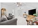 Open living room with a ceiling fan, gray sofa, plaid armchair, table with a TV, and neutral-toned walls at 2602 Blue Crane Circle # 101, Myrtle Beach, SC 29577