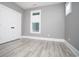Bedroom with gray walls, bright windows, white doors and trim, plus light wood flooring at 261 Marsh Tacky Loop, Myrtle Beach, SC 29588