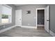 Bedroom features a light gray wall, white door, tv mount, white trim and gray wood flooring at 261 Marsh Tacky Loop, Myrtle Beach, SC 29588