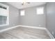 Bedroom featuring light gray walls, white trim, neutral wood flooring and bright windows at 261 Marsh Tacky Loop, Myrtle Beach, SC 29588