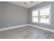 Sunlit bedroom with large window, ceiling fan, and grey walls to maximize comfort and relaxation at 261 Marsh Tacky Loop, Myrtle Beach, SC 29588