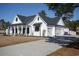 Charming white farmhouse with a gray roof, spacious driveway, and an attached two-car garage at 261 Marsh Tacky Loop, Myrtle Beach, SC 29588