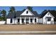 Inviting home exterior with white siding, black shutters, and rocking chair front porch at 261 Marsh Tacky Loop, Myrtle Beach, SC 29588