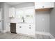 Kitchen with stainless steel dishwasher, white cabinets, a black faucet and marble countertops and backsplash at 261 Marsh Tacky Loop, Myrtle Beach, SC 29588