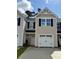 Exterior view of a townhome with a one-car garage, neutral siding, black shutters, and a well-maintained lawn at 265 Christiana Ln. # D, Myrtle Beach, SC 29579