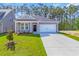 Charming single-story home featuring a manicured lawn and a two-car garage at 409 Sun Colony Blvd., Longs, SC 29568