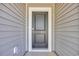 Close-up of a gray front door with white trim, showcasing the home's entryway at 409 Sun Colony Blvd., Longs, SC 29568