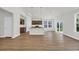 Open-concept kitchen and living area with hardwood floors, kitchen island and stainless steel appliances at 409 Sun Colony Blvd., Longs, SC 29568