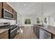 Open kitchen with stainless appliances, granite countertops, a kitchen island, and sliding glass doors to the backyard at 409 Sun Colony Blvd., Longs, SC 29568