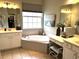 Bright and airy bathroom featuring dual vanities, a soaking tub, and a makeup vanity for a spa-like experience at 414 Grand Cypress Way, Murrells Inlet, SC 29576
