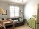 Calm bedroom with a comfortable couch, shuttered windows, and neutral decor with a touch of tropical style at 414 Grand Cypress Way, Murrells Inlet, SC 29576